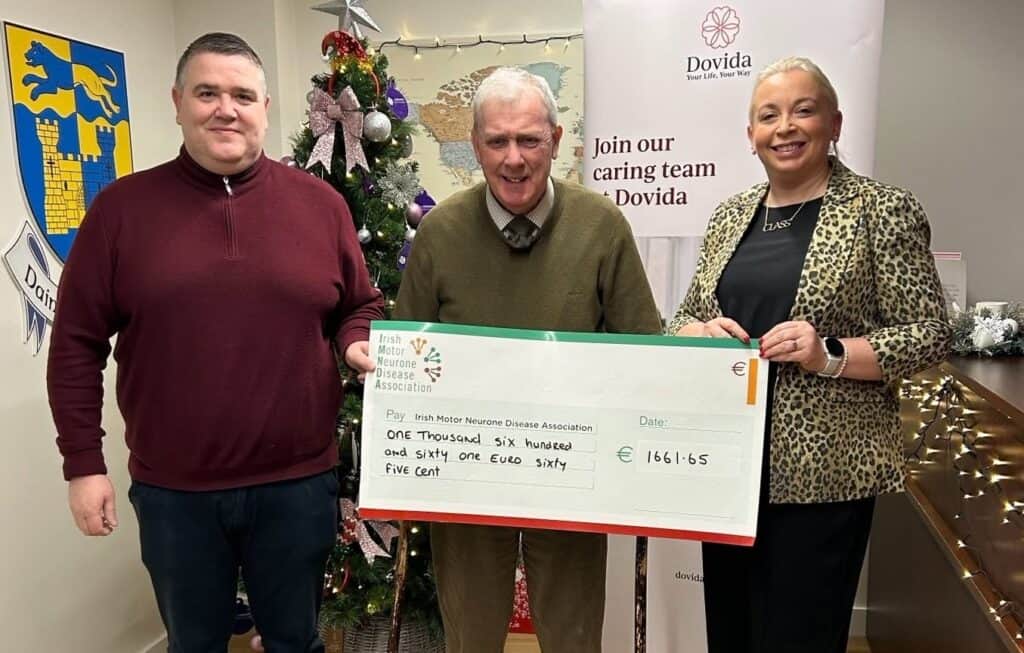Dovida Westmeath hands a charity donation to the IMNDA