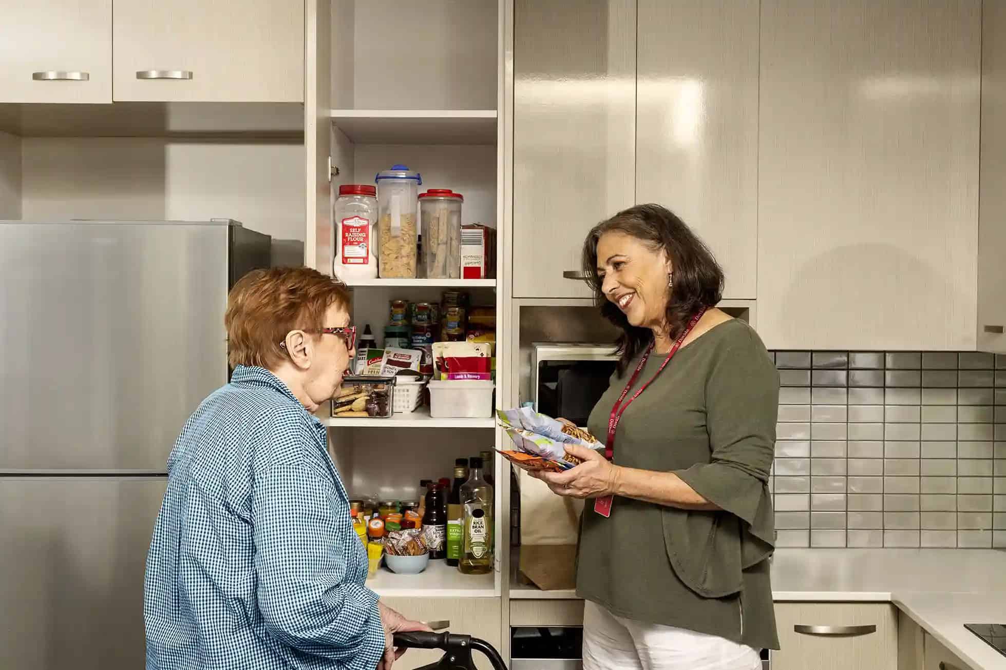 Caregiver helping client with cupboards