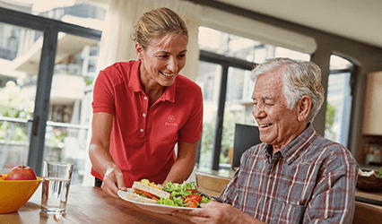 Dovida Caregiver serves health meal to client